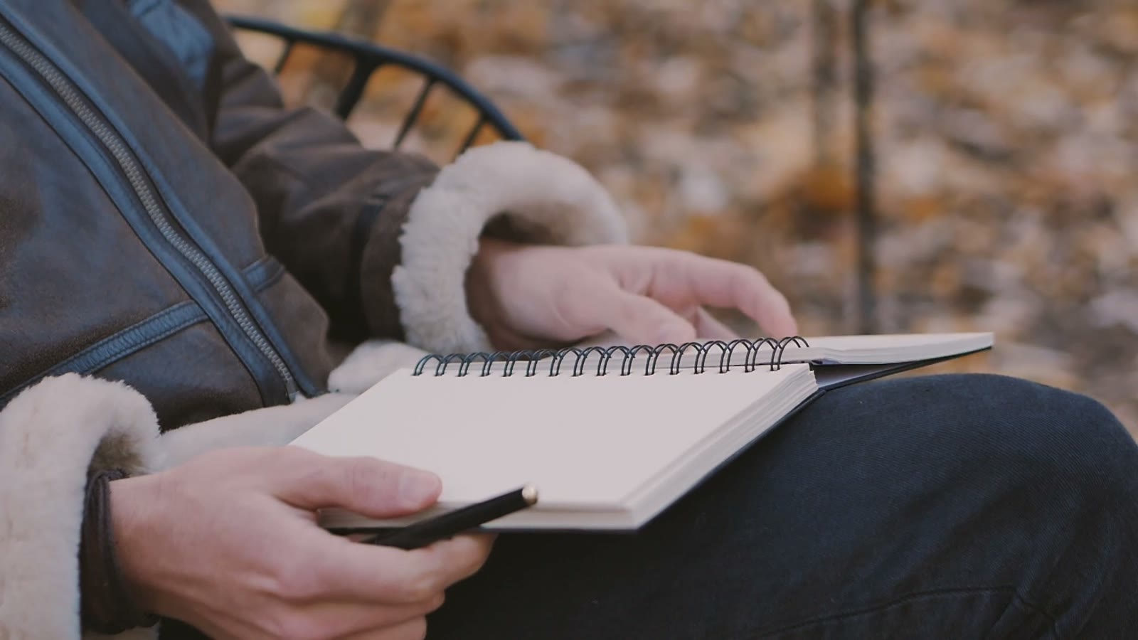 A notebook and pen held outdoors