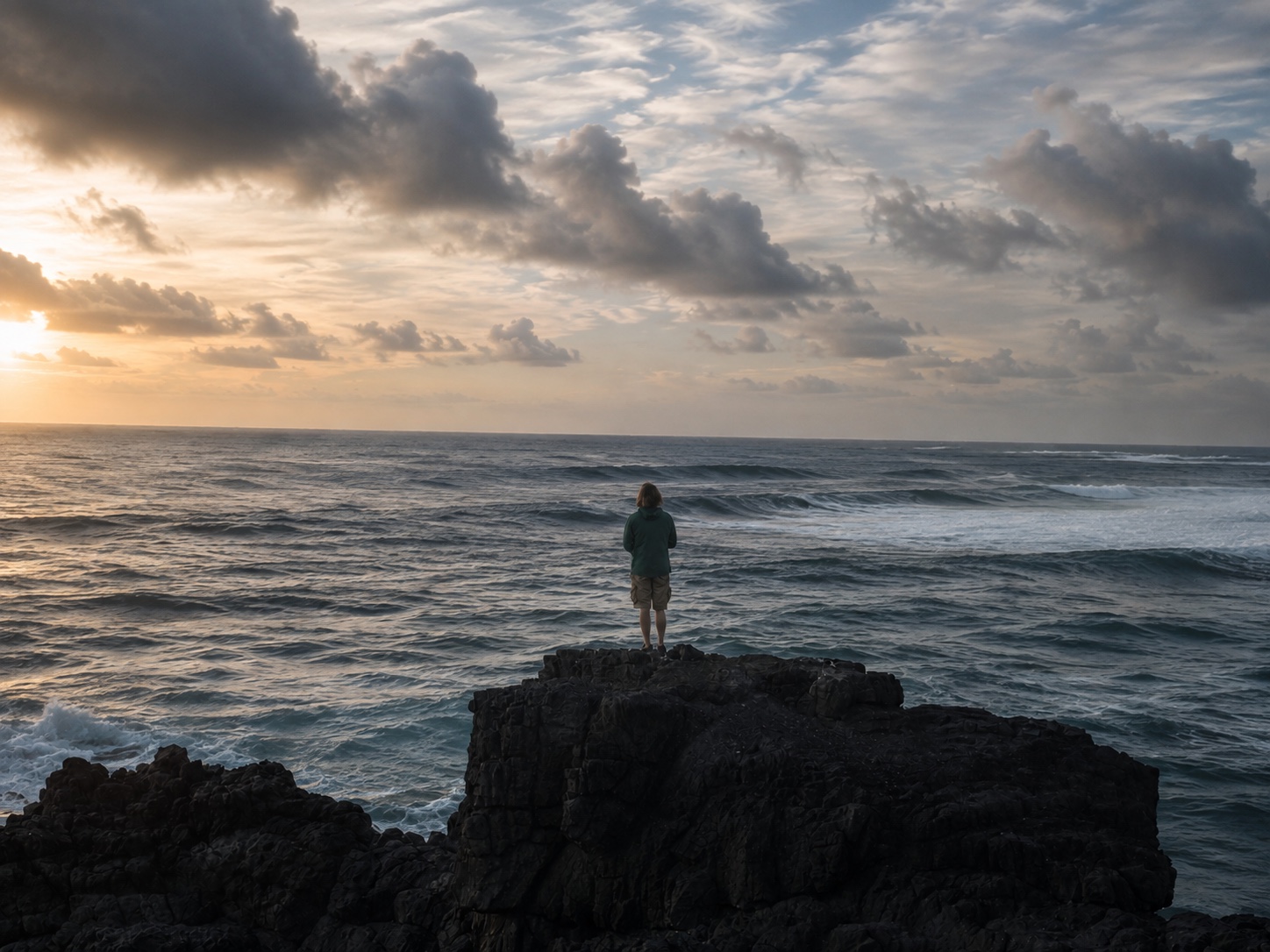 Ruben standing alone on coastal rock facing the open sea