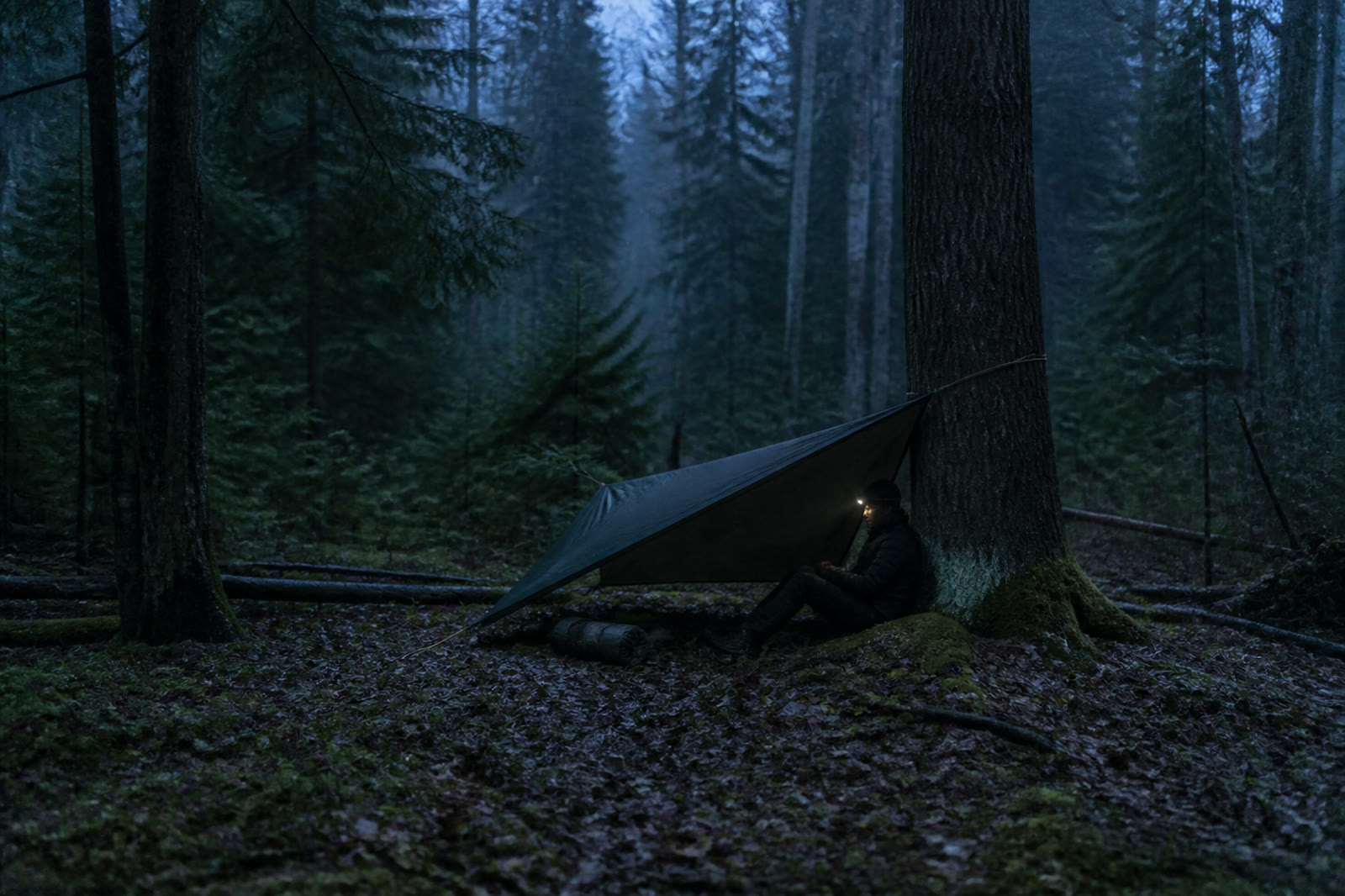 A man alone beneath a simple tarp during the second night