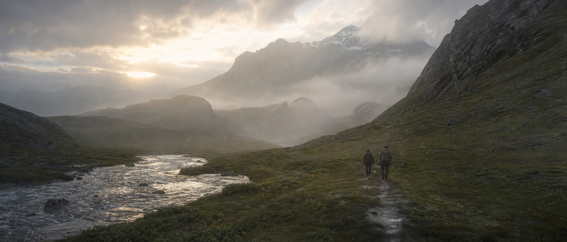 Two men walking beside an alpine river at first light