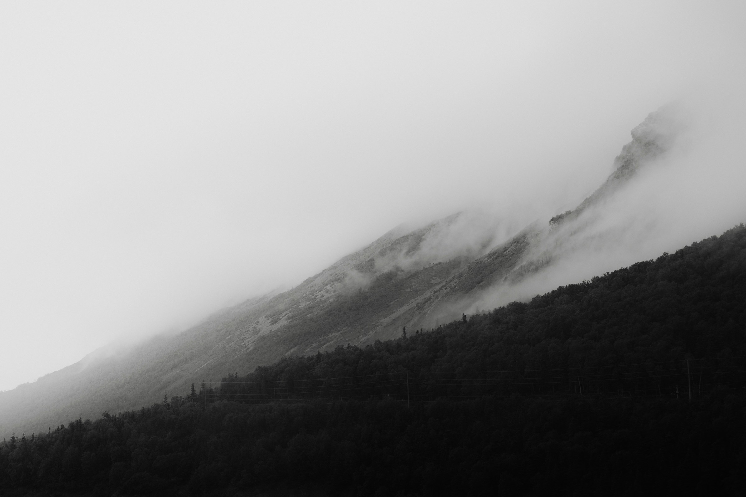 Mountain ridges disappearing into moving fog