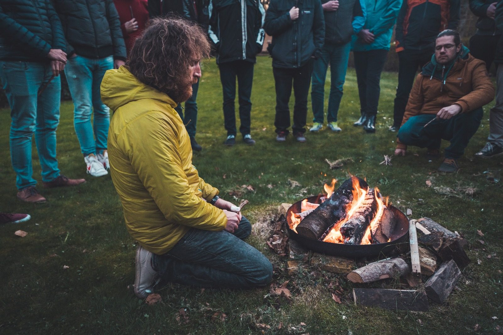 Ruben sitting beside a fire with a group