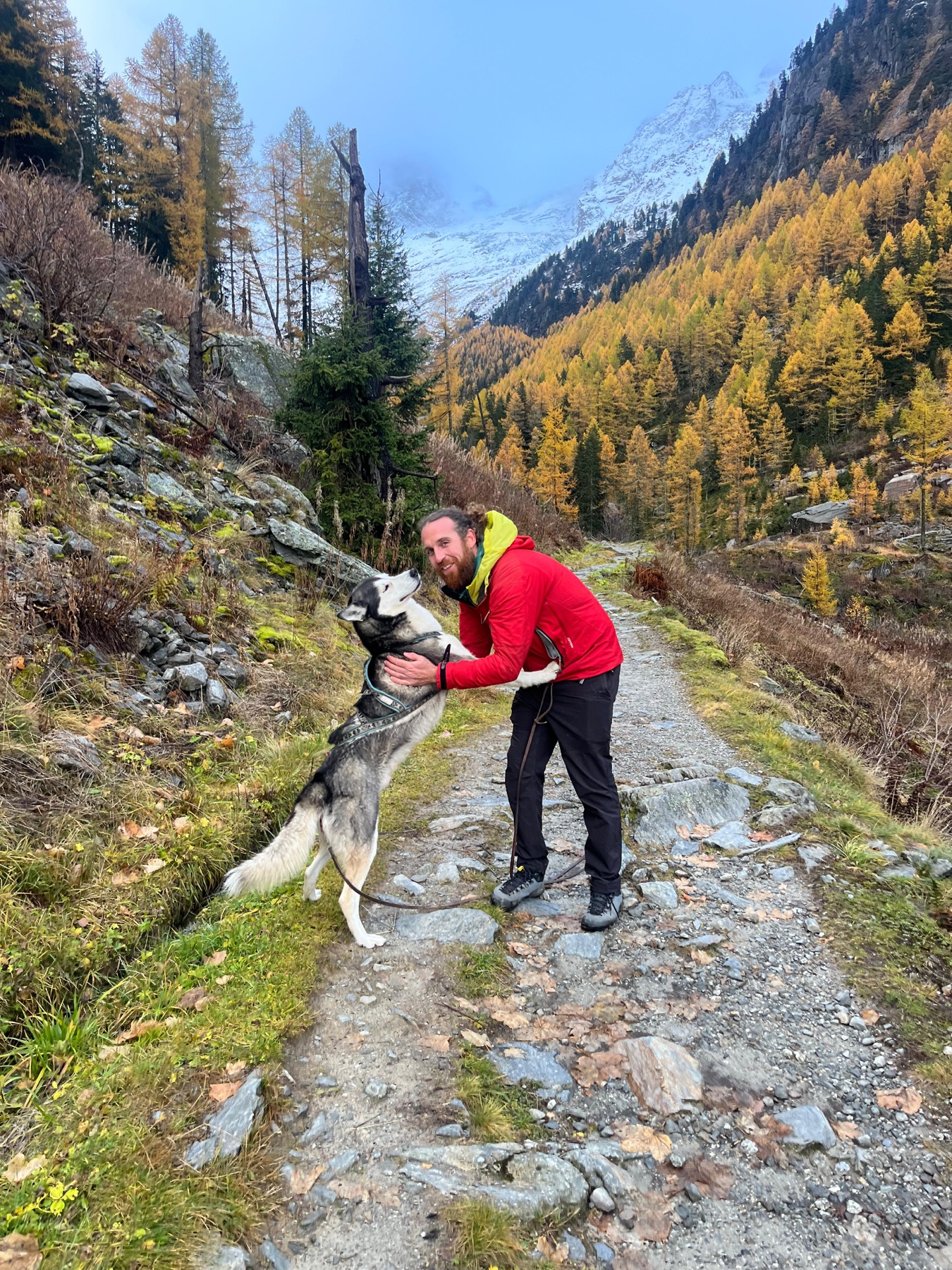 Ruben with his dog on a mountain path in the Swiss Alps