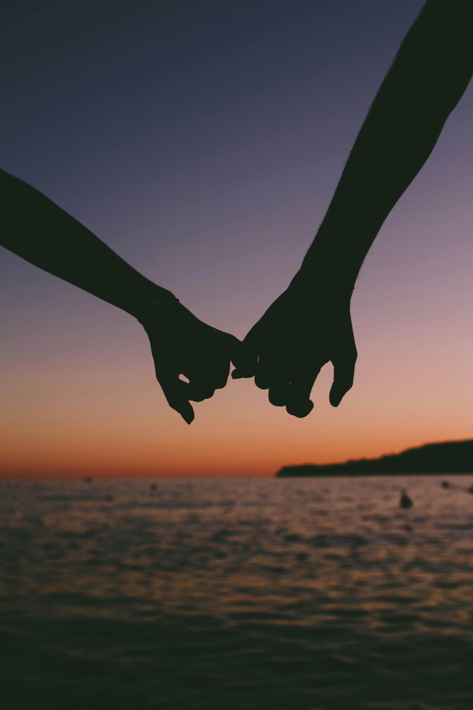 Two people holding hands in warm evening light