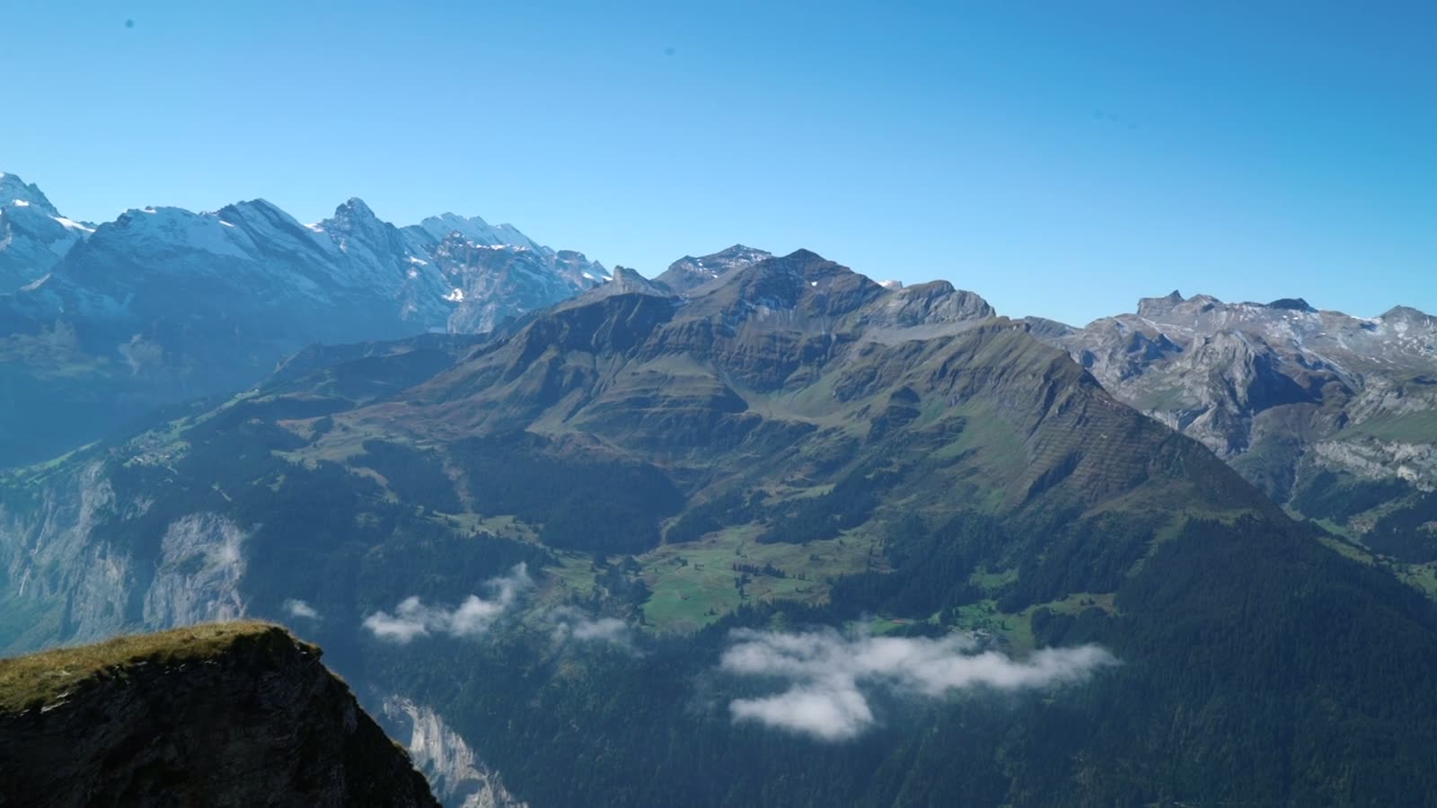 A small group travelling through a vast mountain landscape