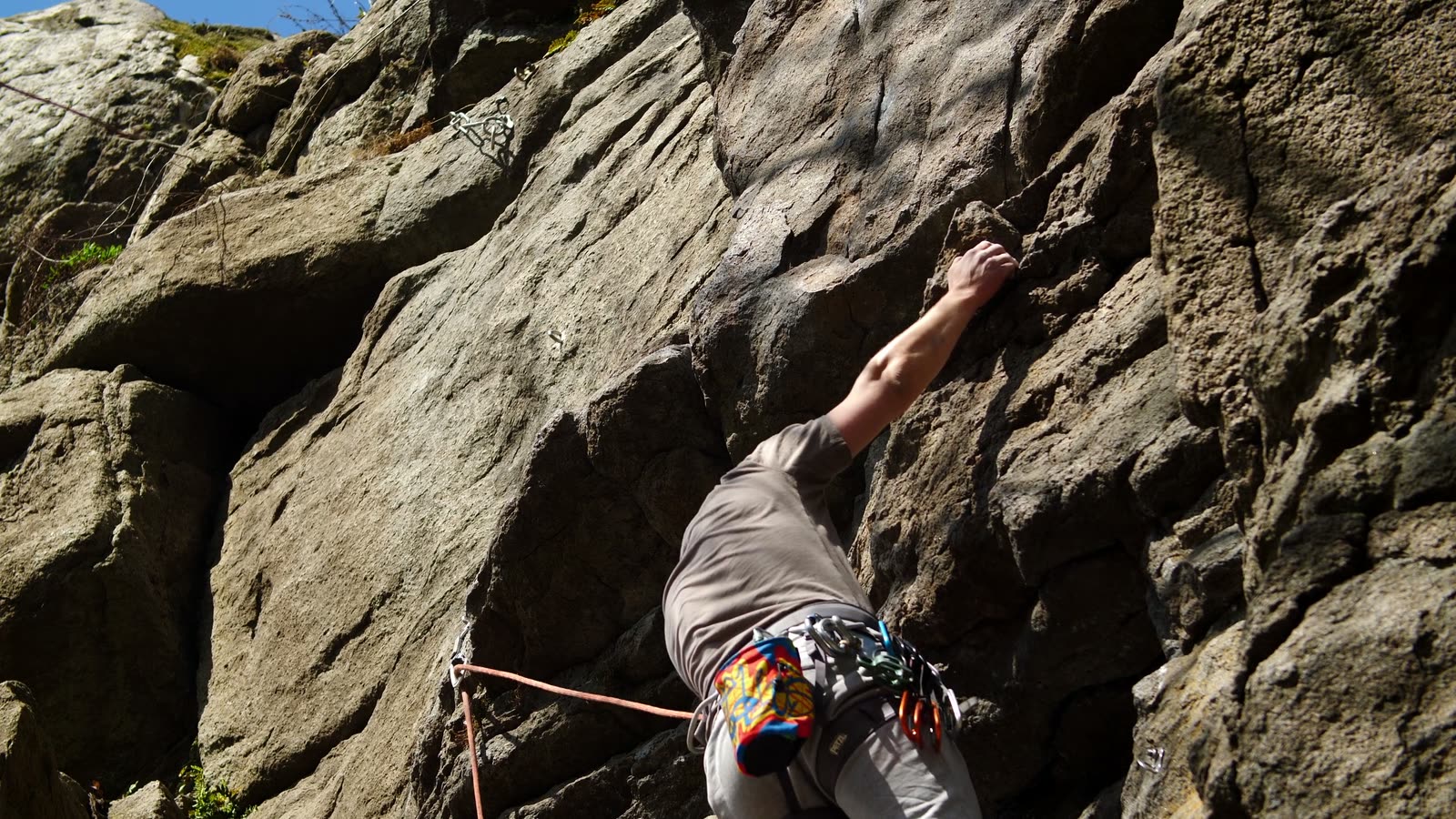 Climber learning on a natural rock wall