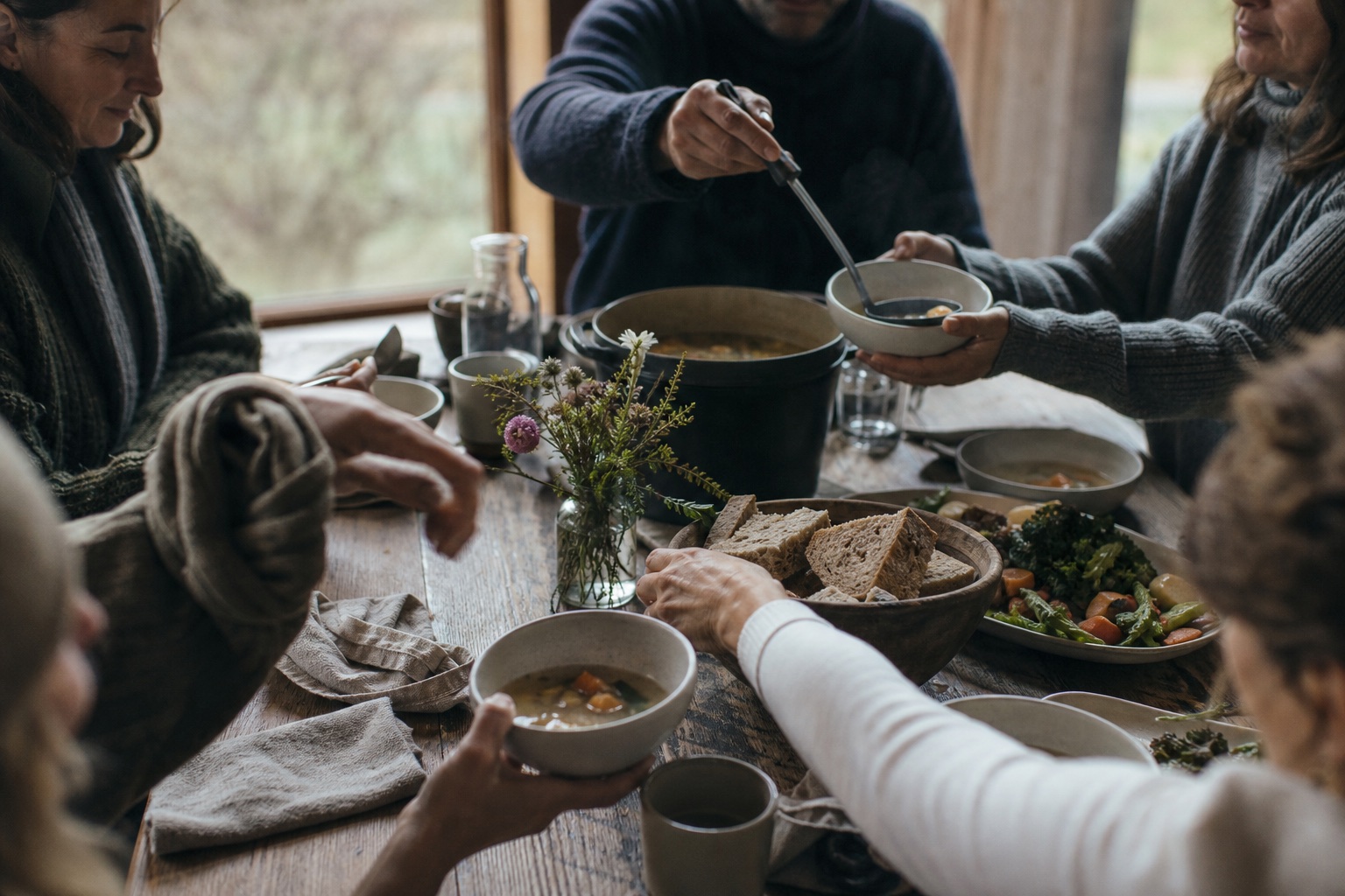 People sharing a simple warm meal around a wooden table